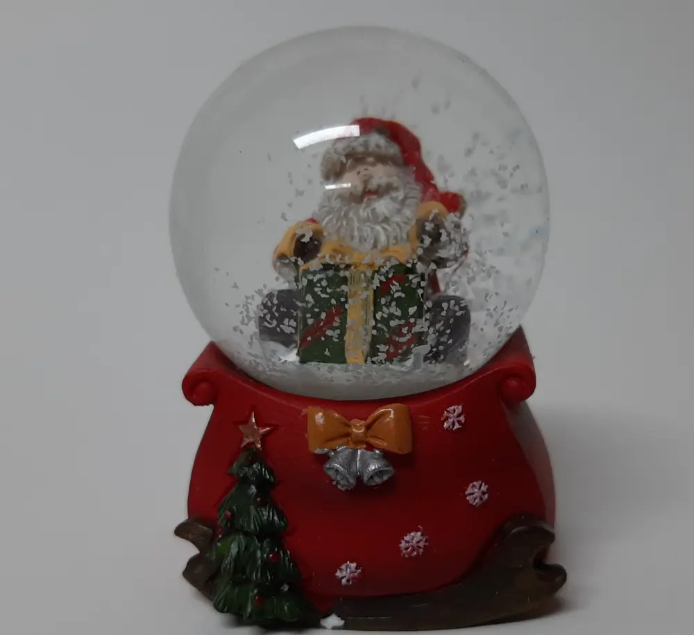 Sneeuwbol cadeauzak op arrenslee en kerstman op groen-rood cadeau