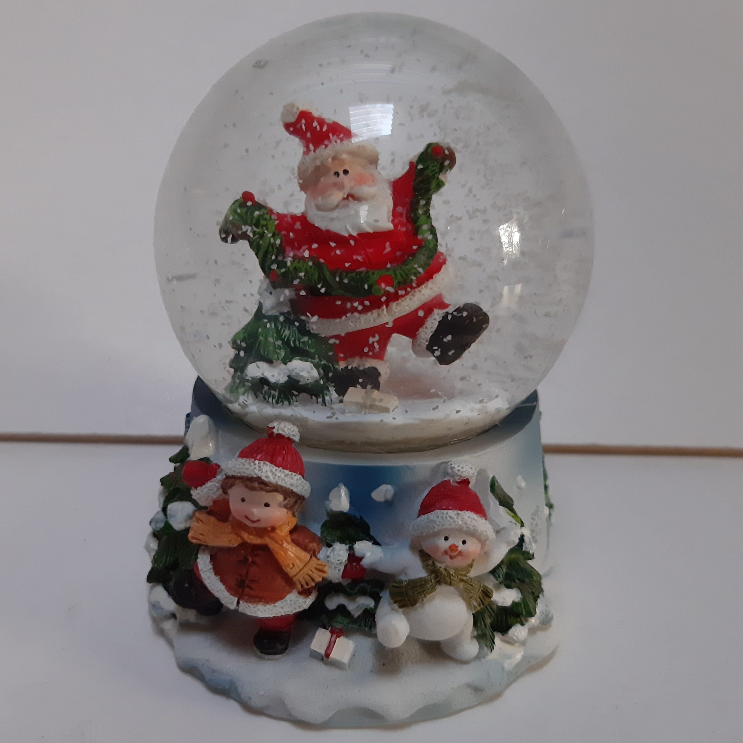 Sneeuwbol kerstman met kerstboom en guirlande op blauwe basis met kerstkind en sneeuwpop 9cm
