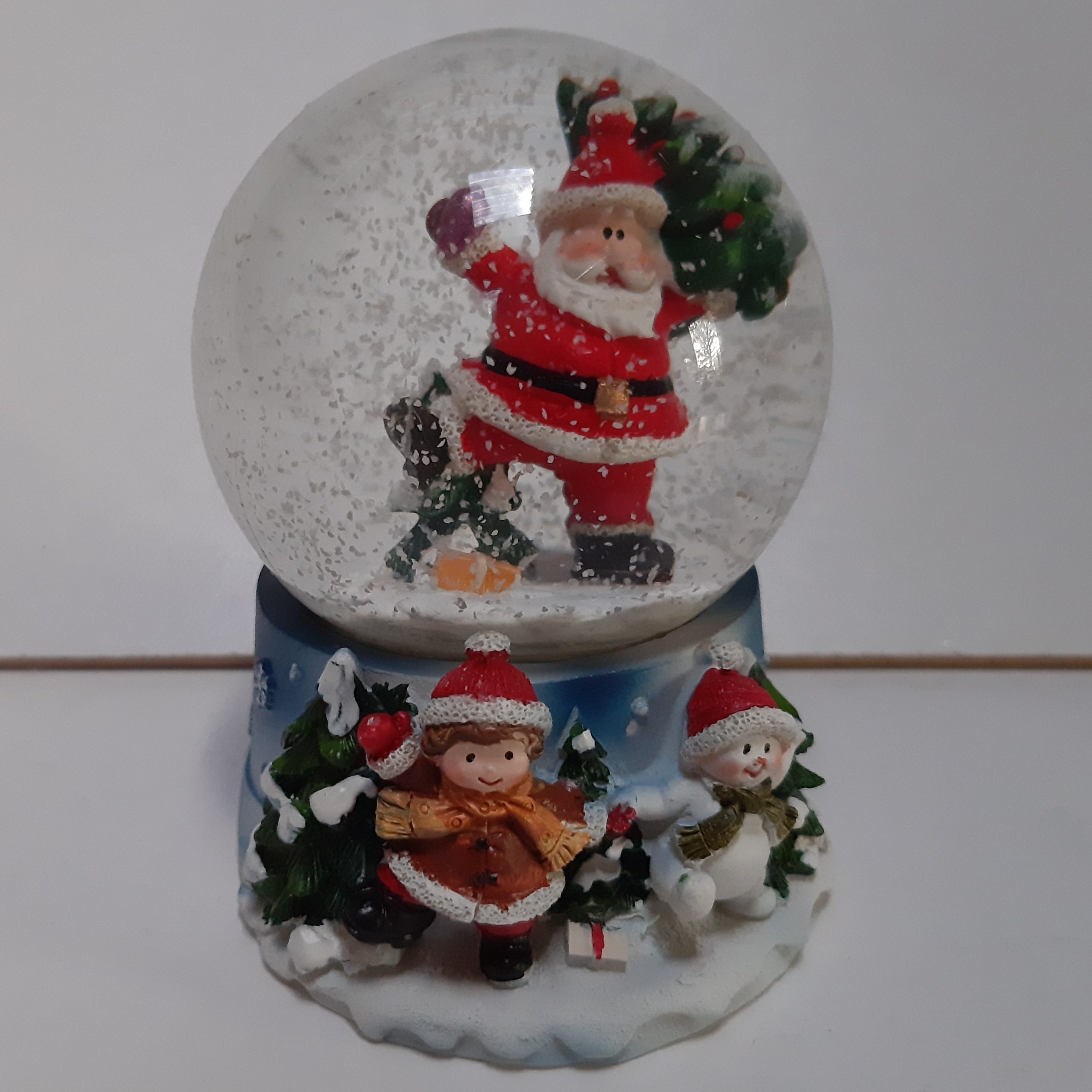 Sneeuwbol kerstman met kerstboom in de hand op blauwe basis met kerstkind en sneeuwpop 9cm